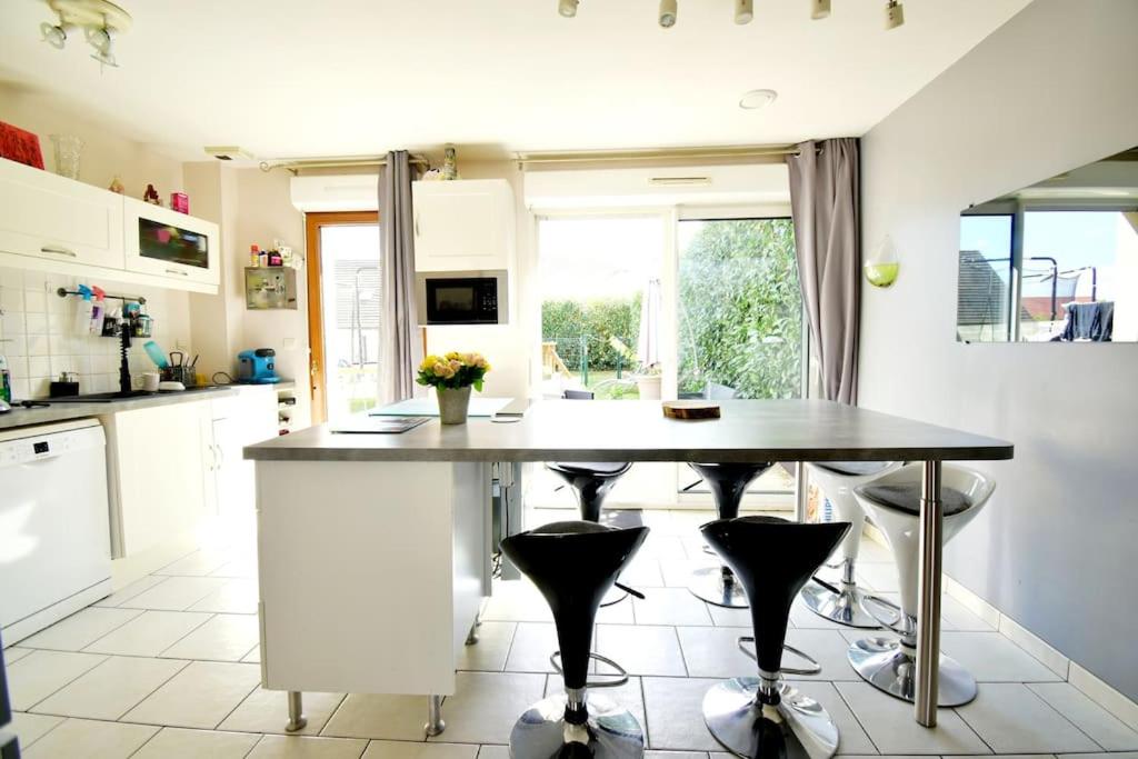 eine Küche mit einem Tisch und zwei Hockern in der Unterkunft Grande maison jusqu'à 9 pers in Ézy-sur-Eure