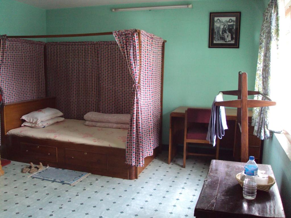 1 dormitorio con 1 cama y 1 cruz en una habitación en Sanu House, en Pātan