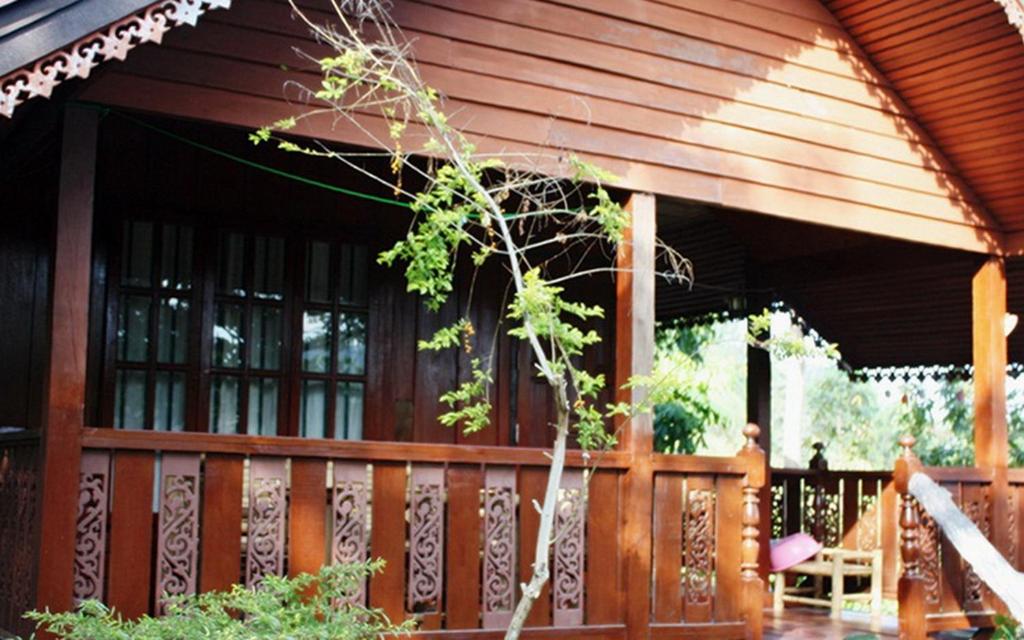 Casa con porche de madera con valla en Utopia House Phangan, en Mae Haad