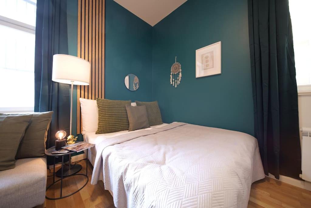 een slaapkamer met een wit bed en een blauwe muur bij Cavallo Business M - 1BD Apartments City Center in Praag