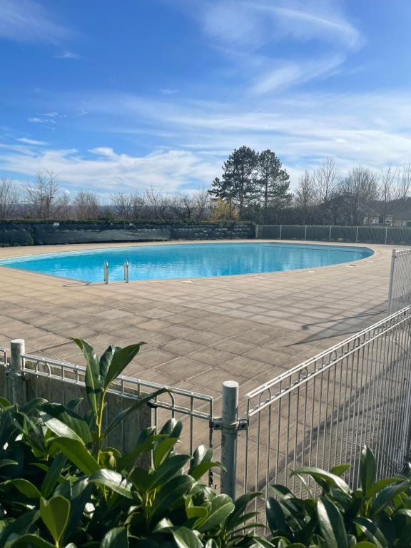 ein großer Pool mit einem Zaun um ihn herum in der Unterkunft Appart 41 Montbéliard: calme et cosy + piscine in Sainte-Suzanne