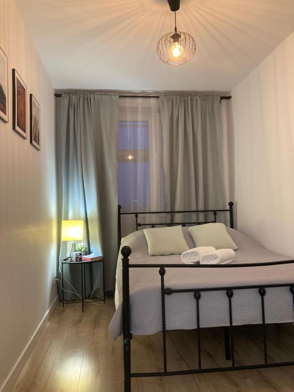 a bedroom with a bed with a lamp and a window at Apartament lovely space in Rzeszów