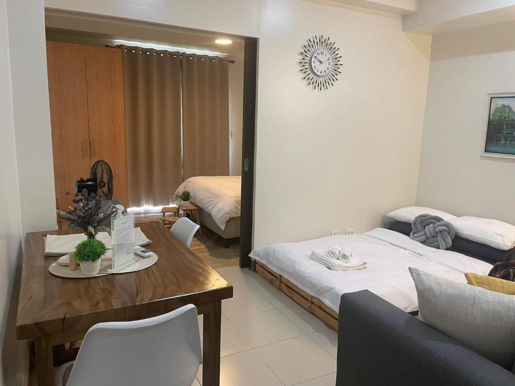 a living room with a bed and a table and a bedroom at 1 Bedroom Condo near ICC Megaworld with netflix in Iloilo City