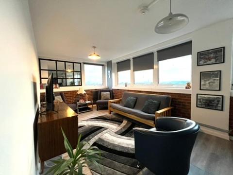 a living room with a couch and chairs and a table at Amazing view 2 bedroom in Abbey Road in London