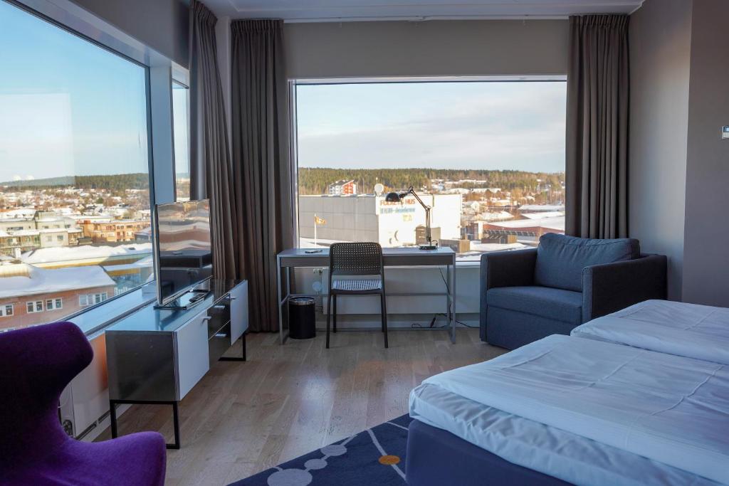 a hotel room with a bed and a desk and a window at Comfort Hotel Winn in Umeå