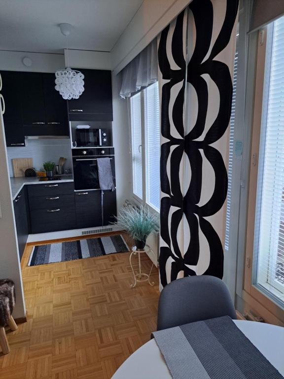 a kitchen with a black and white wall at Saunallinen yksiö in Pieksamaki