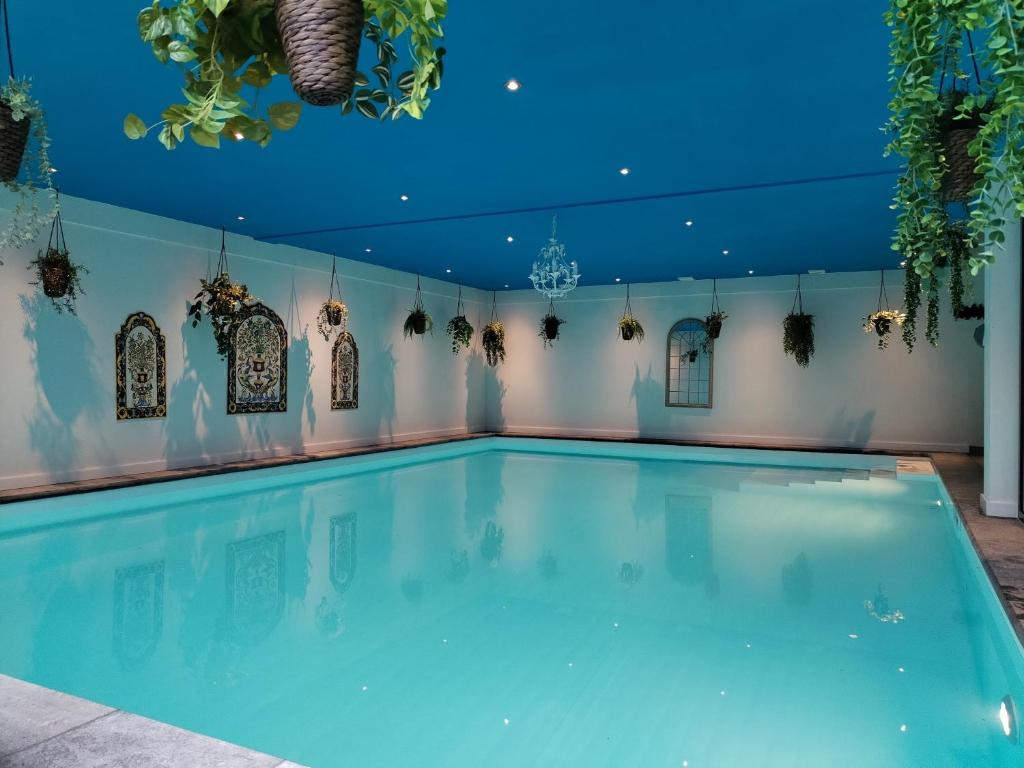 een groot zwembad met een blauw plafond bij B&B Wellness Soest in Soest