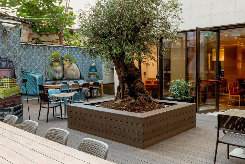 a tree in a planter in front of a restaurant at Nobel Palace Hotel in Belgrade
