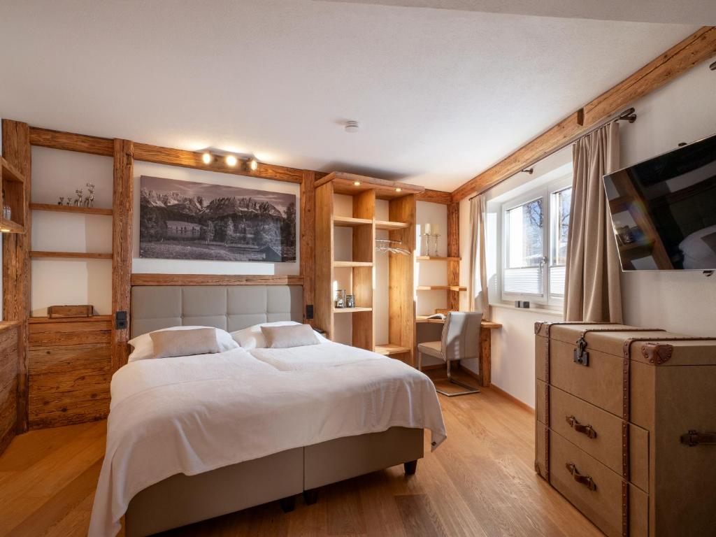a bedroom with a large bed and a desk at Tirol Chalet Brixen in Brixen im Thale
