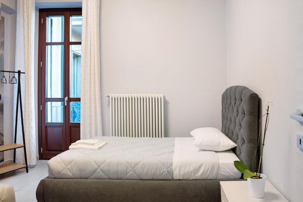 een witte slaapkamer met een bed en een raam bij Civico 16 in Saluzzo