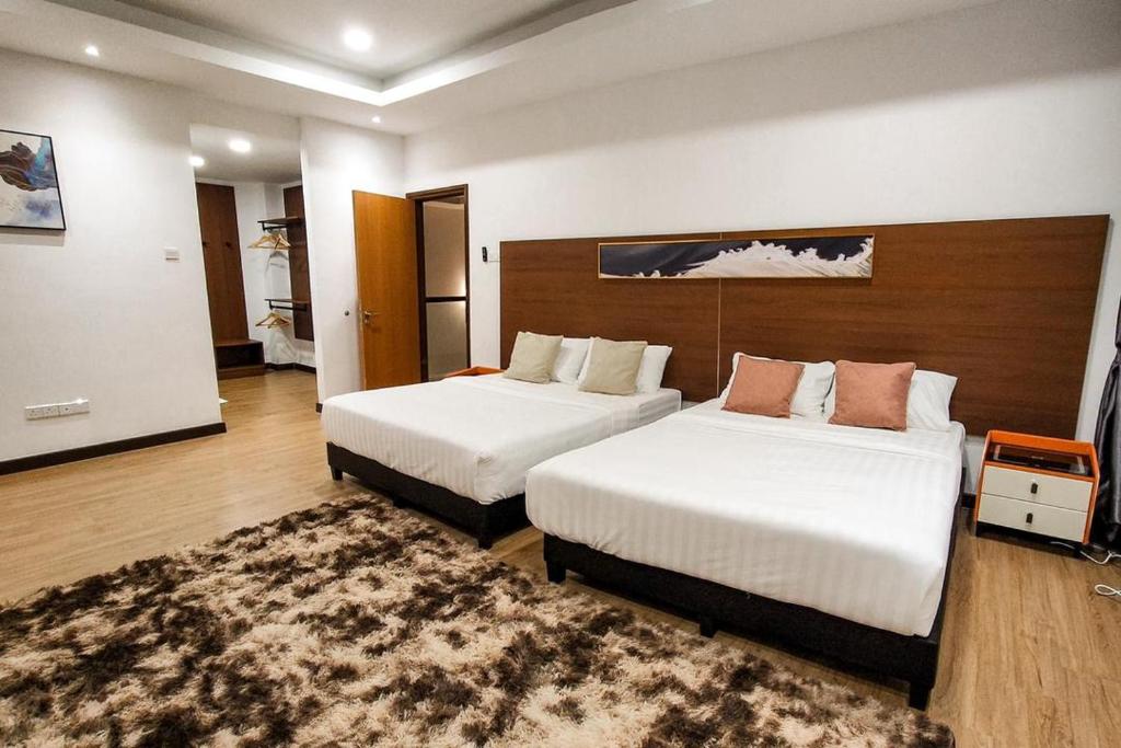 a hotel room with two beds and a rug at ZINNIA RESIDENCE in Tanah Rata