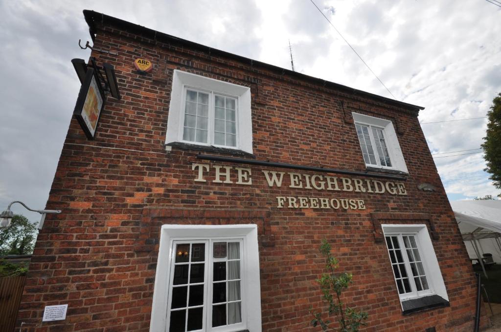 a red brick building with a sign on it at Above The Pub in Alvechurch