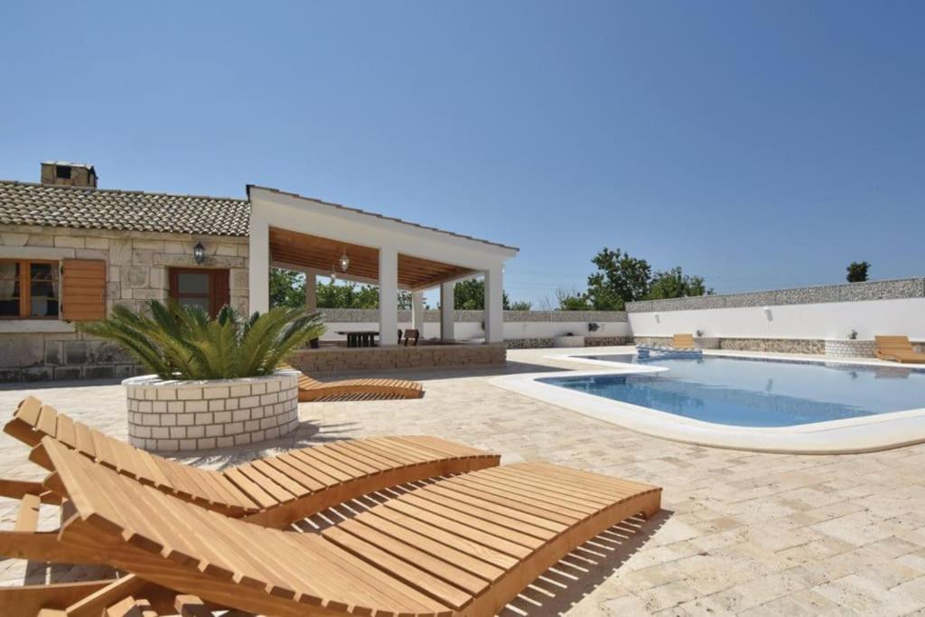patio con sedia e piscina di Apartments with private pool a Trogir
