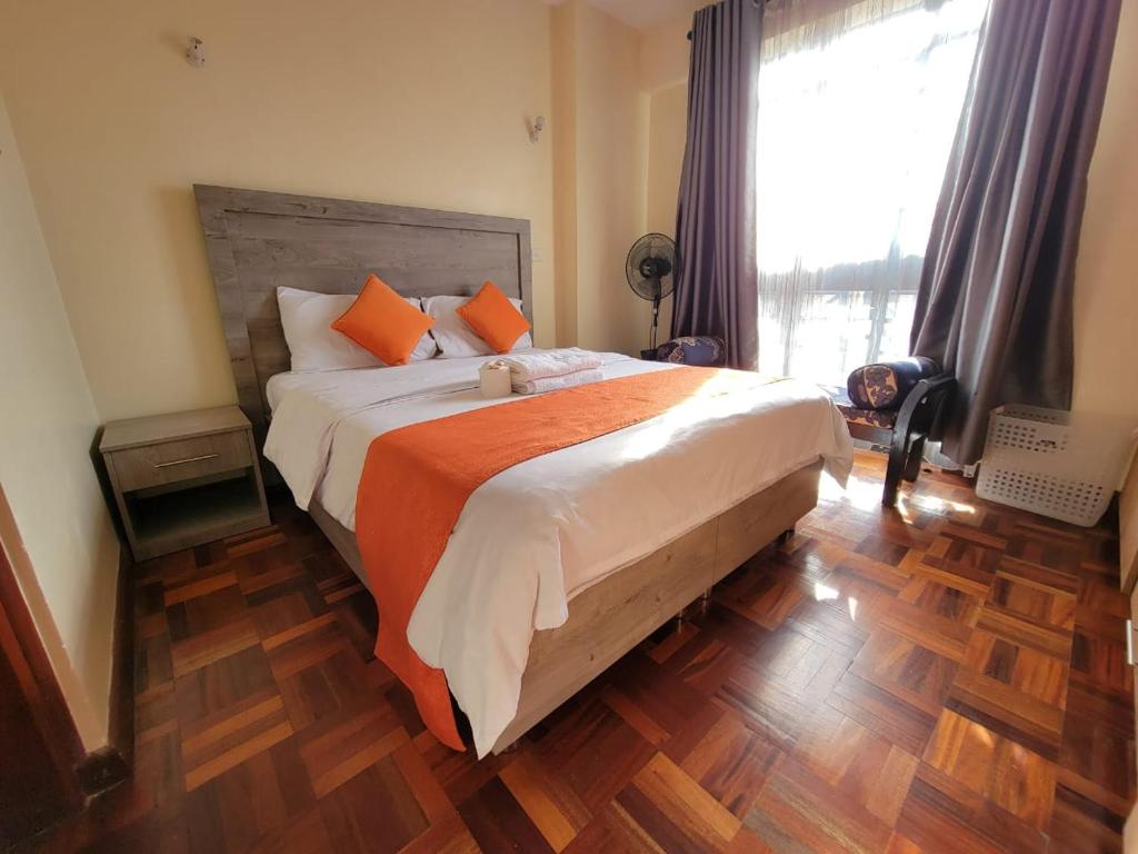 - une chambre avec un grand lit et une couverture orange dans l'établissement Wplace - Westlands, à Nairobi