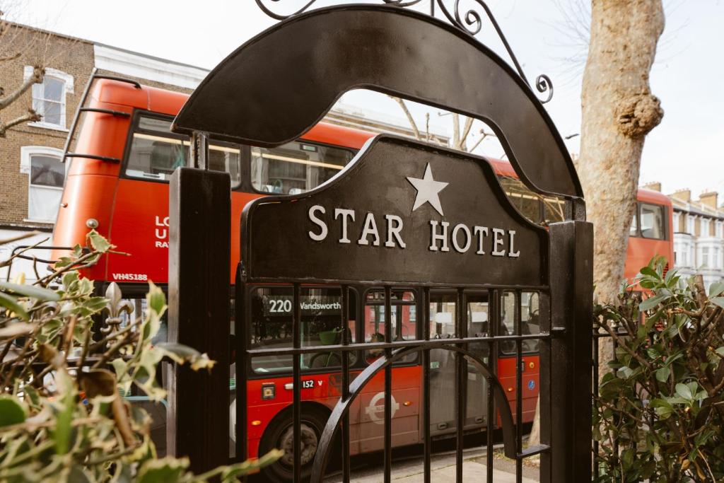 una señal de hotel estrella frente a un autobús en Star Hotel, en Londres