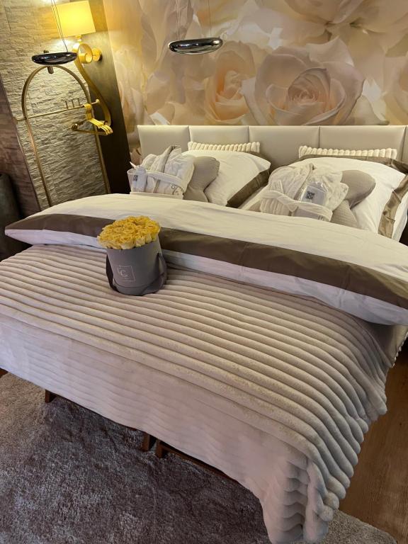 イダー・オーバーシュタインにあるSkinSpa Apartments Idar-Obersteinの花瓶付きの白い大型ベッド