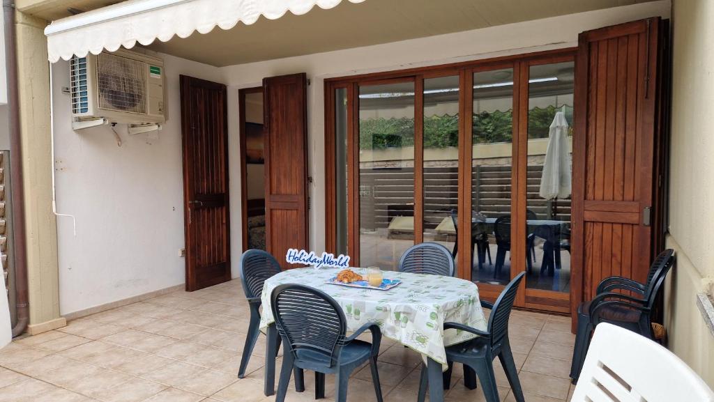 a dining room with a table and chairs on a patio at Appartamento Marina by Holiday World in Santa Teresa Gallura