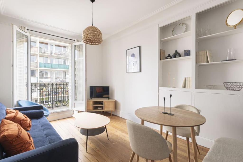 un salon avec un canapé bleu et une table dans l'établissement Apartment 1 Bedroom # Paris 14 # Alesia, à Paris