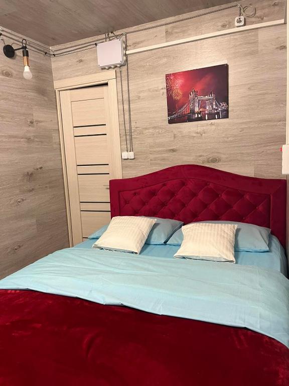 Bett mit rotem Kopfteil in einem Zimmer in der Unterkunft Мини отель in Chişinău