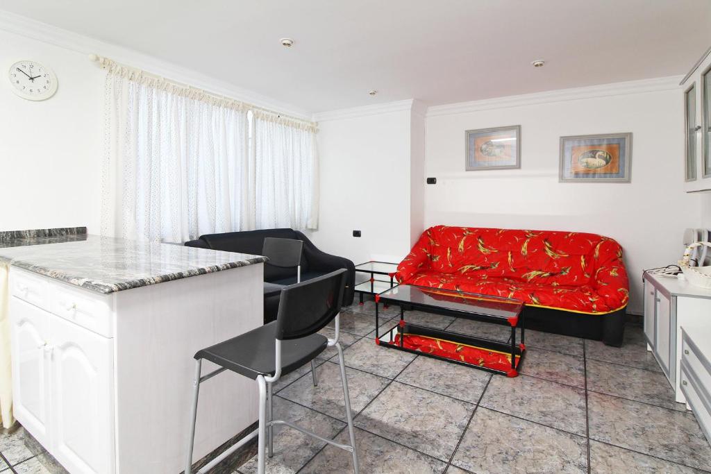 sala de estar con sofá rojo y mesa en Global Properties, Piso centrico en Puerto de Sagunto y comodo en Puerto de Sagunto