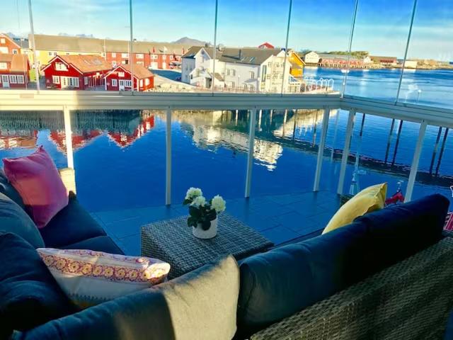 a couch and a table with a view of the water at Svolvær Havn Apartments in Svolvær