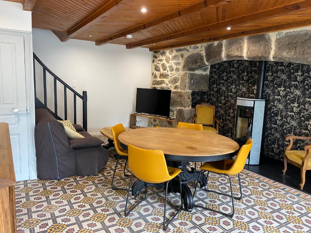 Una habitación con una mesa y sillas y un televisor. en Maison Curières, en Curières