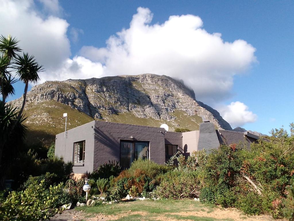 a house with a mountain in the background at Streams Cottage in Bettyʼs Bay