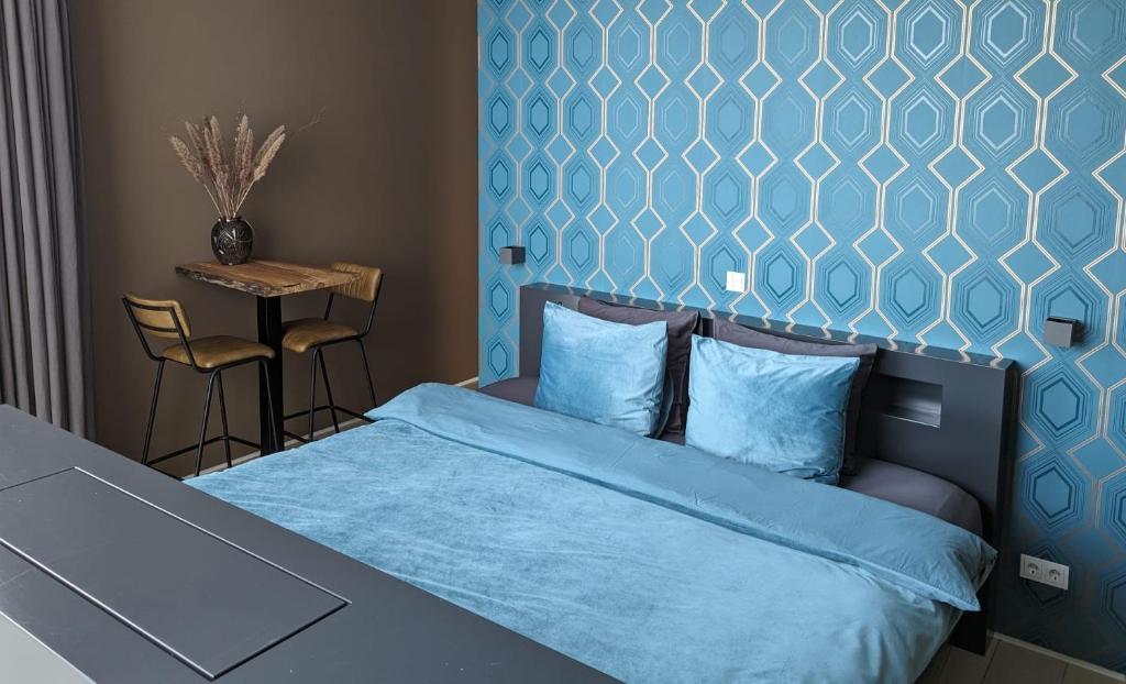 1 dormitorio con 1 cama con pared azul en Bed & Wellness Boxtel, luxe kamer met airco en eigen badkamer, ligbad en Boxtel