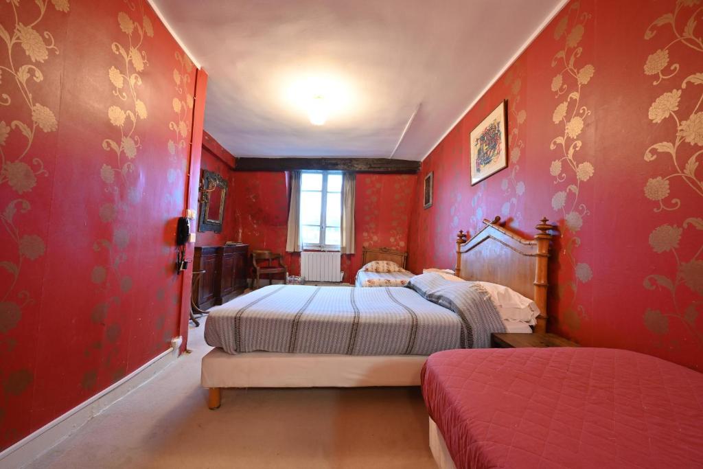 a bedroom with two beds and red walls at Hotel Esmeralda in Paris