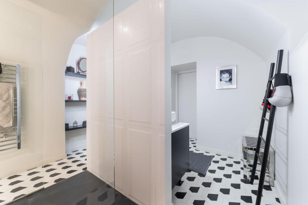 a hallway with white walls and a black and white checkered floor at Wonderful luxury house at 10min from Paris in Meudon