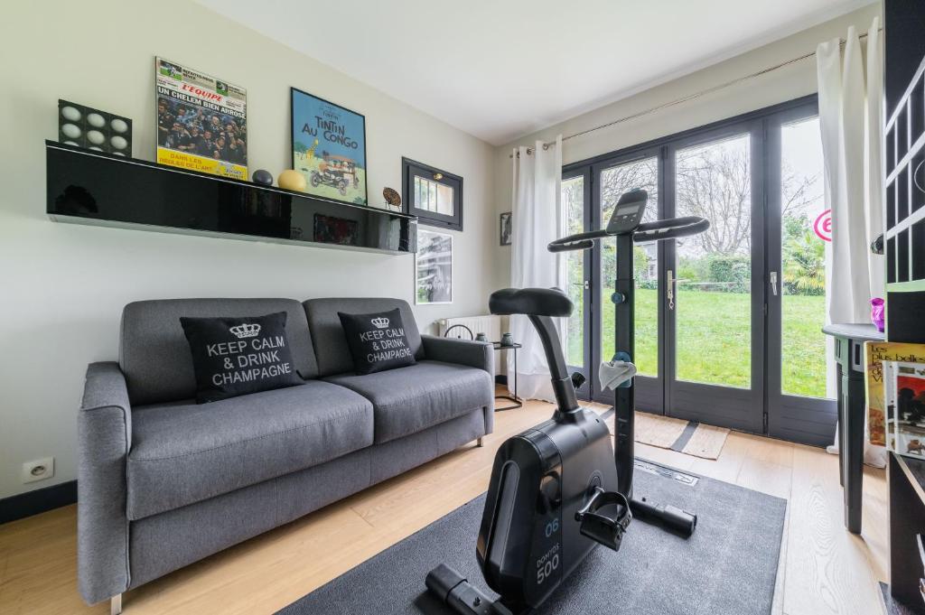 a living room with a couch and a exercise bike at Wonderful luxury house at 10min from Paris in Meudon