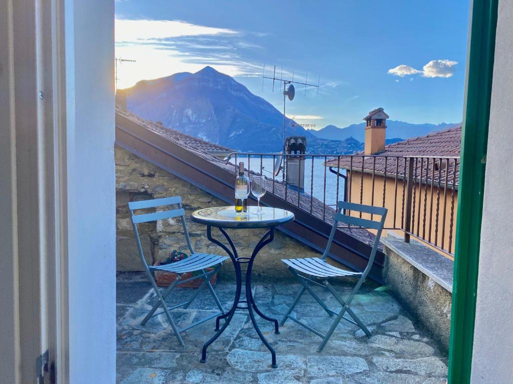 een tafel en 2 stoelen op een balkon met uitzicht bij CHIAVE DI VOLTA Lovely Guesthouse with Terrace in Varenna