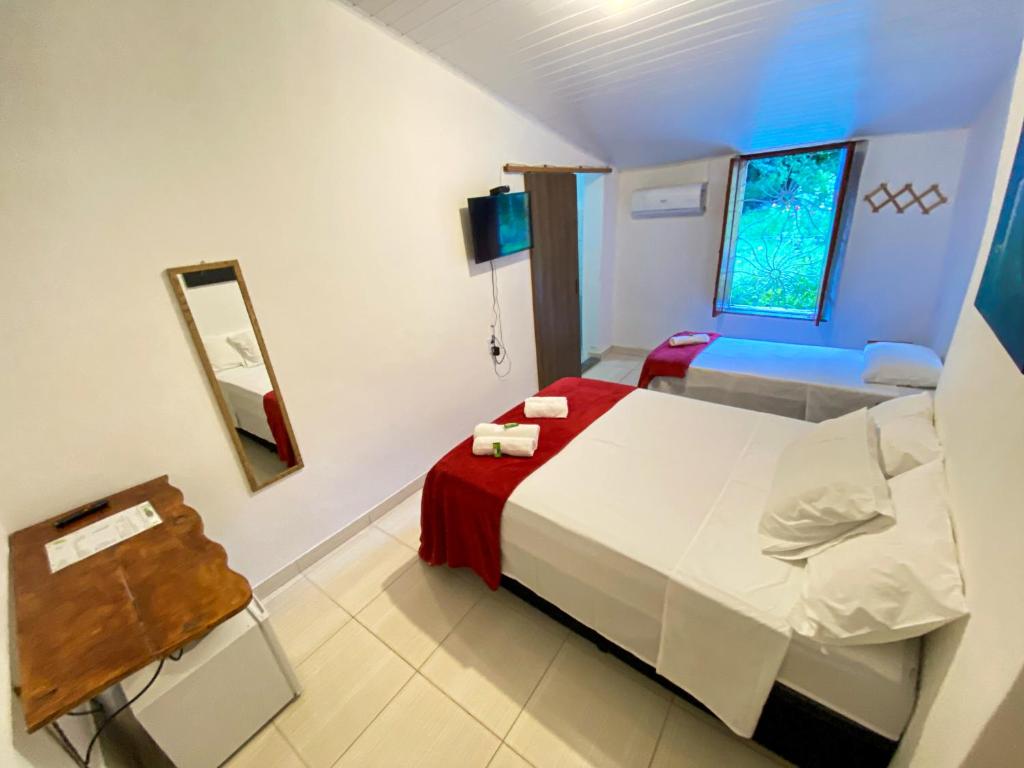 Cette petite chambre comprend un lit et un miroir. dans l'établissement Pousada Jardim Lençóis, à Lençóis