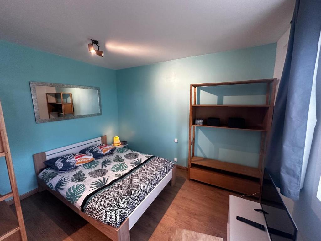 Dormitorio pequeño con cama y espejo en Le Panorama-centre ville, en Niort