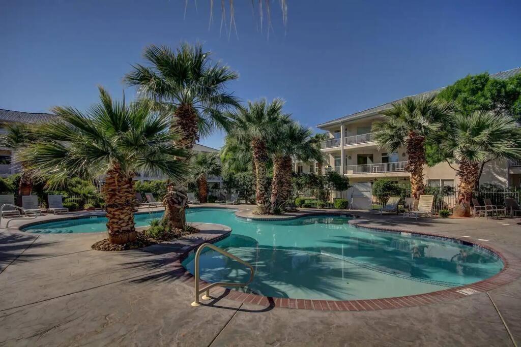 a swimming pool with palm trees in front of a building at Ultimate St. George Vacation Retreat! in St. George