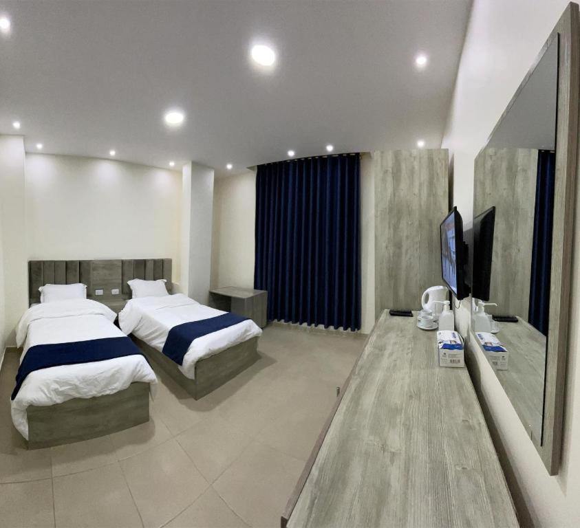 1 dormitorio con 2 camas y TV de pantalla plana en Petra Heaven Boutique, en Wadi Musa