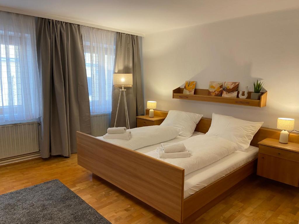 um quarto com uma cama grande num quarto com janelas em Zentrale Wohnung Gmunden Alte Bäckerei em Gmunden