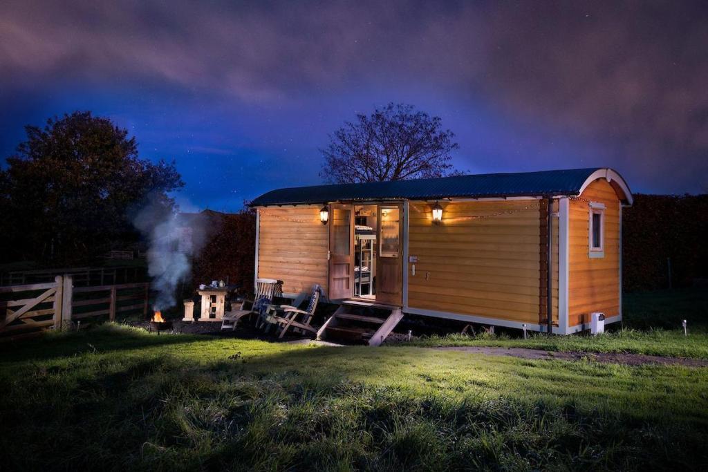 una pequeña cabaña de madera en un campo por la noche en Teasel Shepherd's Hut, en Berwick-Upon-Tweed