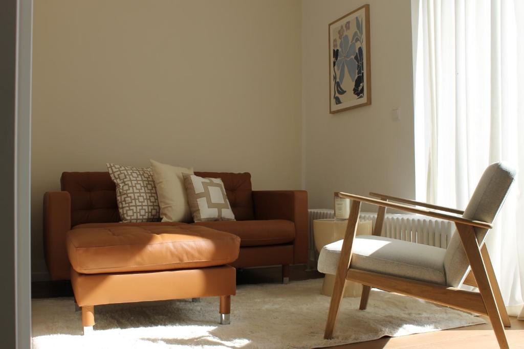 un soggiorno con un divano e una sedia di Boutique Wohnung mit Domblick a Paderborn