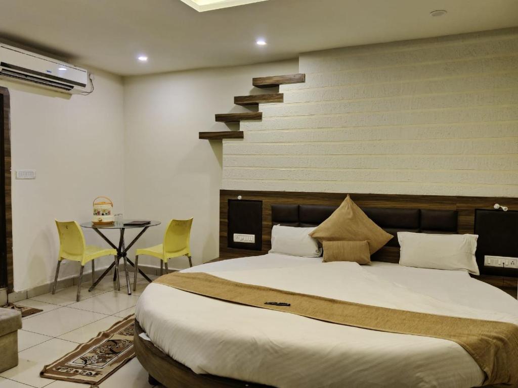 a bedroom with a bed and a table and a staircase at Abhilasha hotel pachmarhi` in Pachmarhī