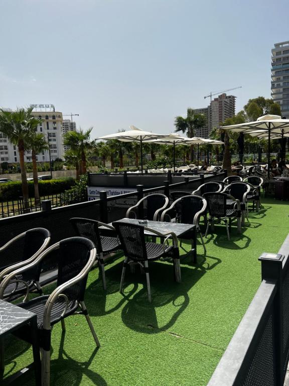 a row of tables and chairs with umbrellas at Duplex familial 3 chambres au cœur de la Corniche de Tanger in Tangier