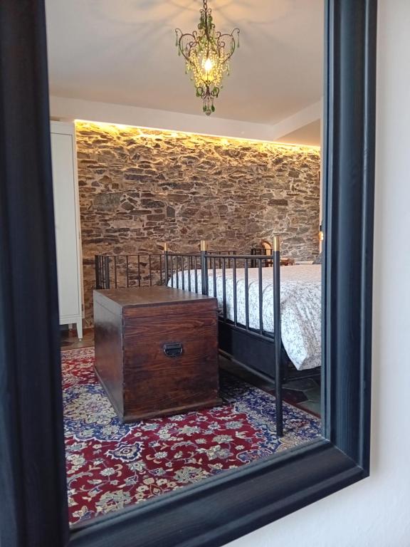uno specchio che riflette una camera con letto e tronco in legno di Casa Longhi a Orta San Giulio