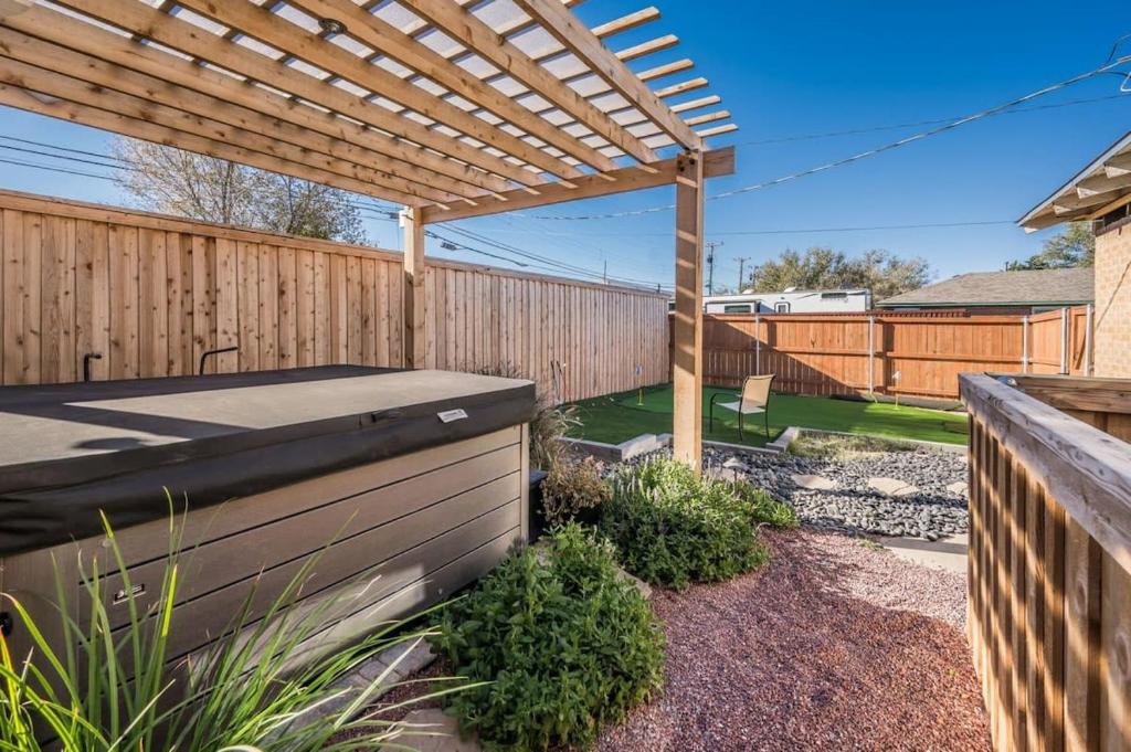 a backyard with a wooden fence and a pergola at Amazing Hot tub l Sleeps 14 in Amarillo