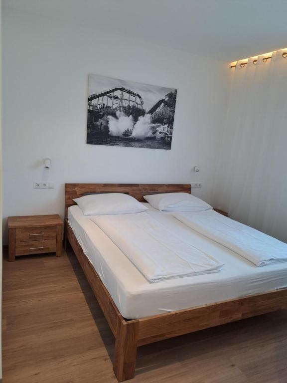 a bedroom with a large bed with a bridge on the wall at Pension am Park in Rust