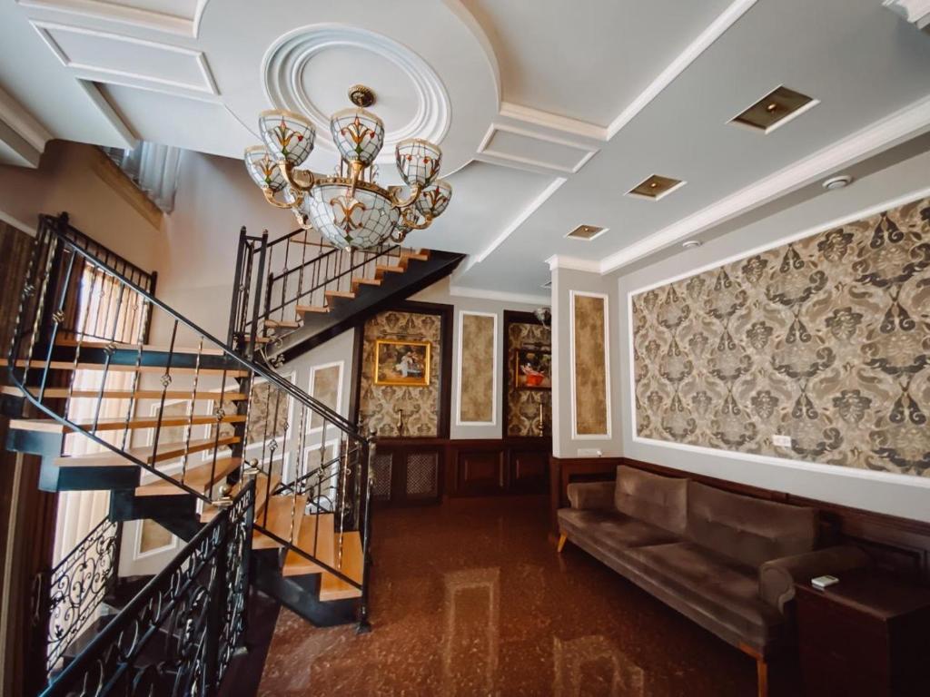 a staircase in a house with a chandelier at Royal Renaissance Hotel in Yerevan