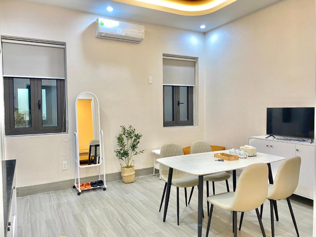 a dining room with a white table and chairs at G-space apartment in Hai Phong