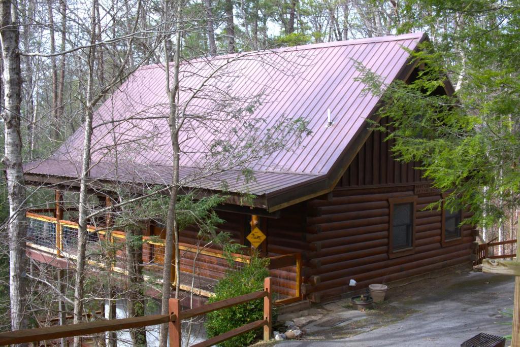 une cabine dans les bois avec un toit rouge dans l'établissement Mick's Hideaway - Semi-Secluded, à Sevierville