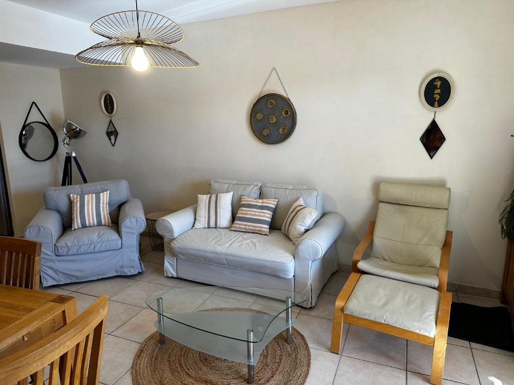a living room with two couches and a glass table at Marina Ivoire in Aigues-Mortes