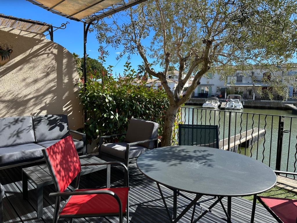 a table and chairs on a patio next to a body of water at Marina Ivoire in Aigues-Mortes