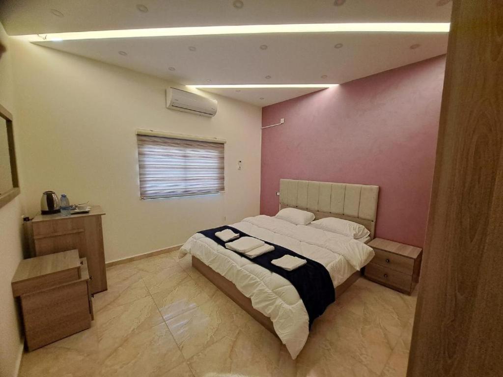 Un dormitorio con una cama grande y una pared rosa en Petra Heaven Boutique, en Wadi Musa